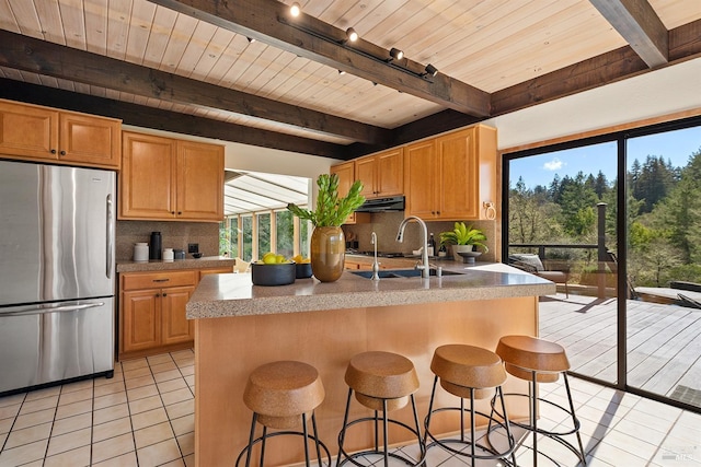 3651 Bones Rd, Sebastopol, CA 95472 - kitchen with freestanding refrigerator, under cabinet range hood, light tile patterned floors, wood ceiling, and healthy amount of natural light