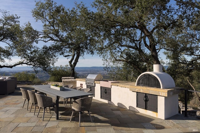 view of patio / terrace with area for grilling, a grill, and outdoor dining space