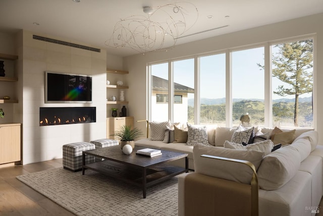 living area featuring built in shelves, wood finished floors, and a fireplace