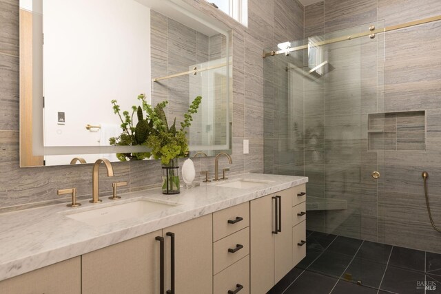 bathroom with tile patterned floors, double vanity, a shower stall, and a sink