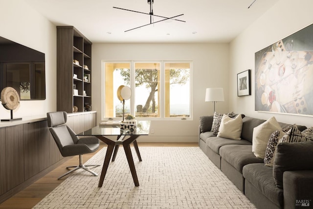 living room featuring a notable chandelier and light wood-type flooring