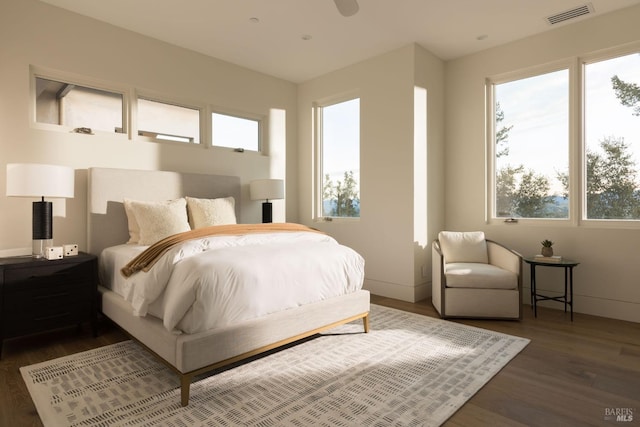 bedroom featuring visible vents, baseboards, and dark wood-type flooring
