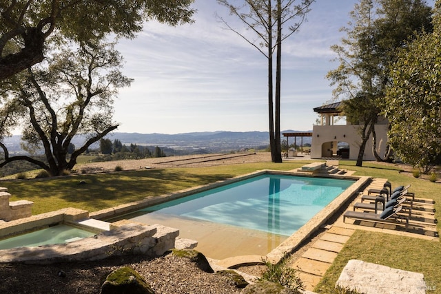 pool with a yard, a patio, and an in ground hot tub
