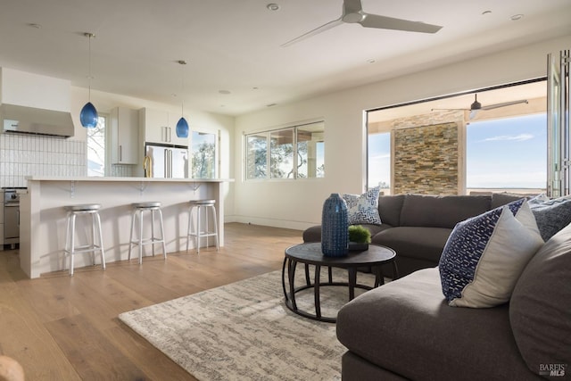 living room featuring light wood-style flooring, plenty of natural light, and ceiling fan