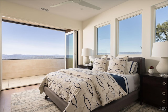 bedroom featuring a ceiling fan, wood finished floors, and visible vents