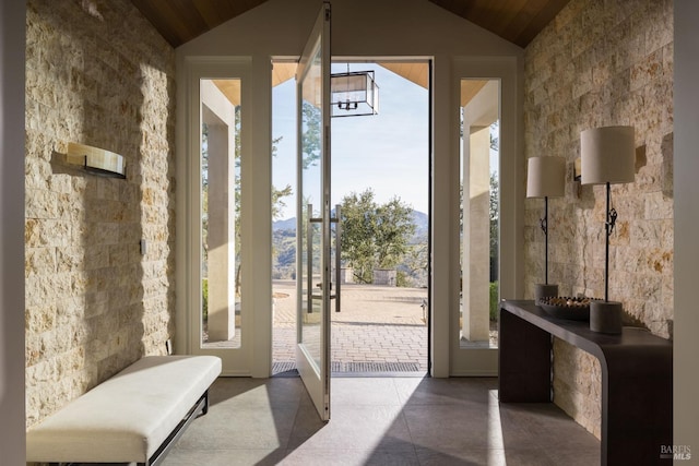entryway featuring vaulted ceiling, a notable chandelier, and wood ceiling