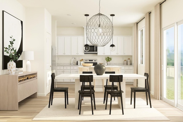 kitchen featuring a wealth of natural light, stainless steel microwave, and light wood-style floors