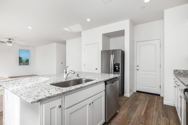 kitchen with white cabinetry, a sink, dark wood-style floors, a kitchen island with sink, and appliances with stainless steel finishes