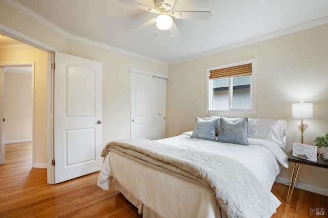 bedroom featuring a closet, a ceiling fan, ornamental molding, light wood finished floors, and baseboards
