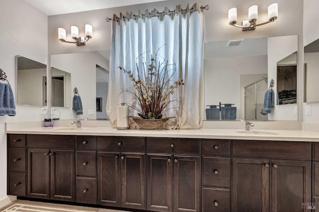 full bath featuring a sink, double vanity, and a stall shower