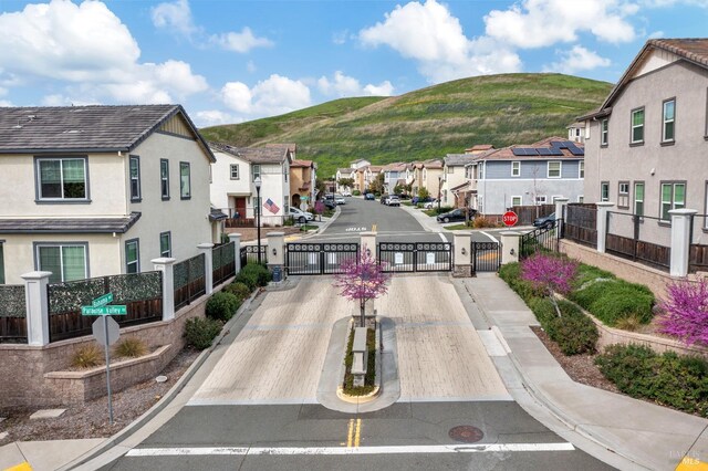 surrounding community featuring a gate, a residential view, fence, and a mountain view