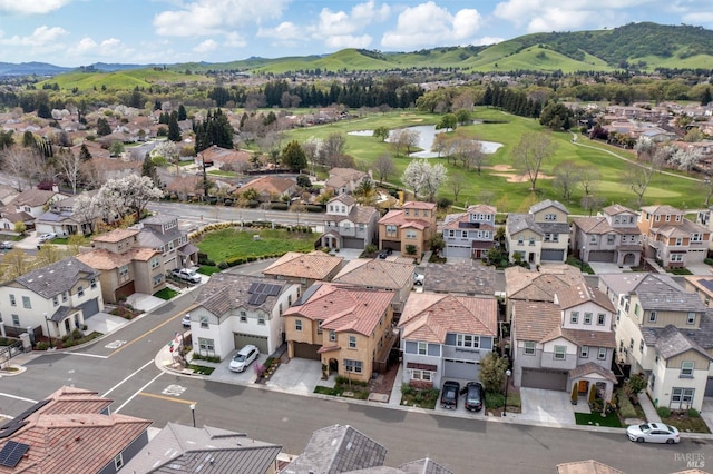 drone / aerial view with a residential view, view of golf course, and a water and mountain view