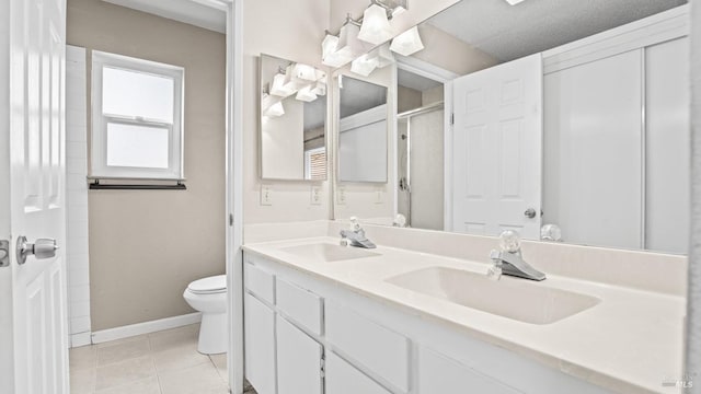 full bath featuring tile patterned flooring, toilet, baseboards, and a sink