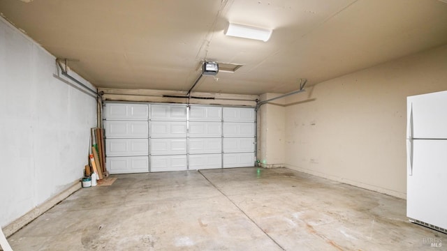 garage with a garage door opener and freestanding refrigerator