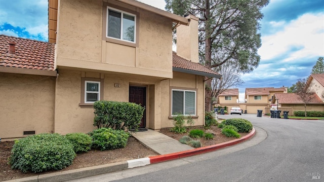 view of front of house featuring stucco siding and a tiled roof