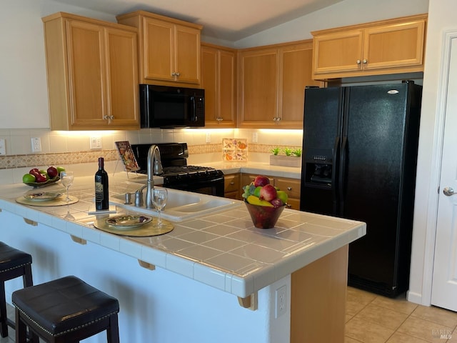 501 Three Rivers Ct, Rio Vista, CA 94571 - kitchen featuring a peninsula, a kitchen bar, tile counters, and black appliances