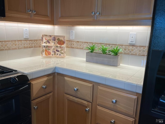 501 Three Rivers Ct, Rio Vista, CA 94571 - kitchen featuring tile counters, black gas range oven, and decorative backsplash