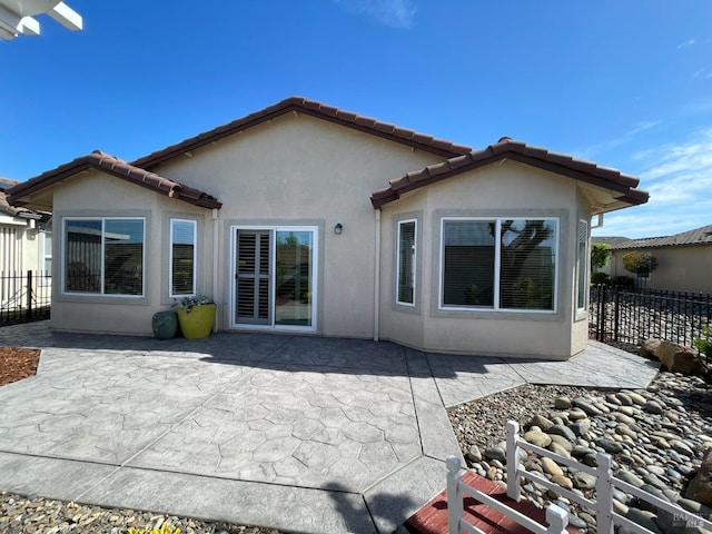 501 Three Rivers Ct, Rio Vista, CA 94571 - back of house with a tiled roof, stucco siding, fence, and a patio area
