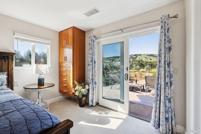carpeted bedroom with visible vents, baseboards, and access to outside