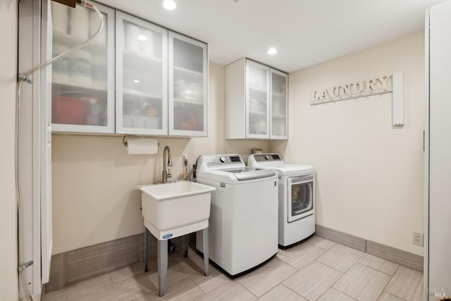 clothes washing area featuring cabinet space, recessed lighting, baseboards, and washing machine and clothes dryer