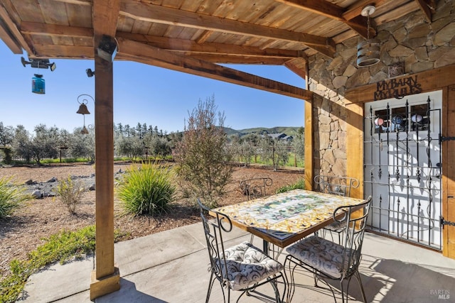 view of patio with outdoor dining space and a mountain view