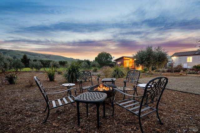 yard at dusk featuring a mountain view and a fire pit
