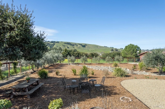 view of yard with a rural view, fence, and a mountain view