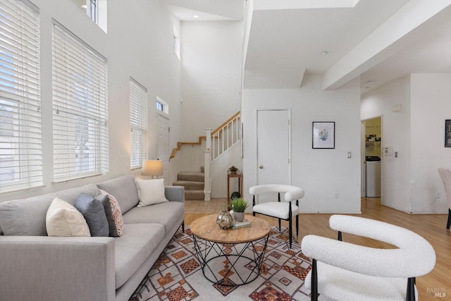330 Windward Cmn Unit 4, Livermore, CA 94551 - living area featuring stairs, a towering ceiling, light wood-style floors, and washer / clothes dryer