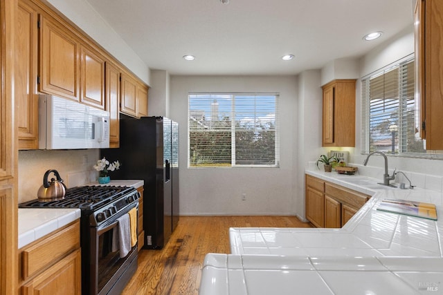 330 Windward Cmn Unit 4, Livermore, CA 94551 - kitchen with white microwave, stainless steel range with gas cooktop, tile countertops, light wood-style floors, and recessed lighting