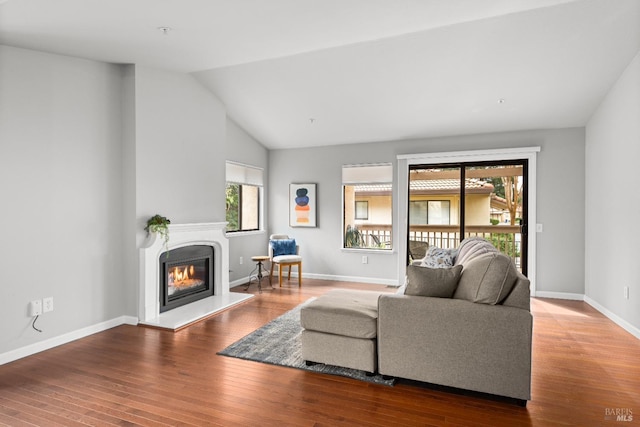 43 Fountain Grove Cir, Napa, CA 94558 - living area with a glass covered fireplace, wood finished floors, vaulted ceiling, and baseboards