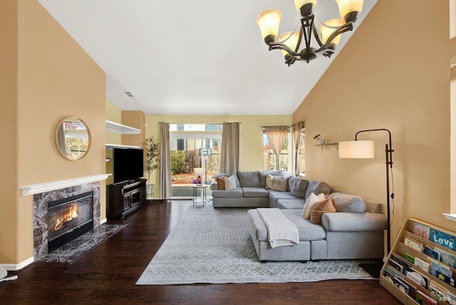 living room with high vaulted ceiling, a premium fireplace, a notable chandelier, dark wood-type flooring, and visible vents