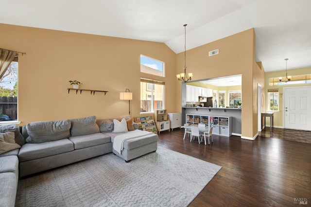 living area with high vaulted ceiling, an inviting chandelier, baseboards, dark wood-style flooring, and visible vents