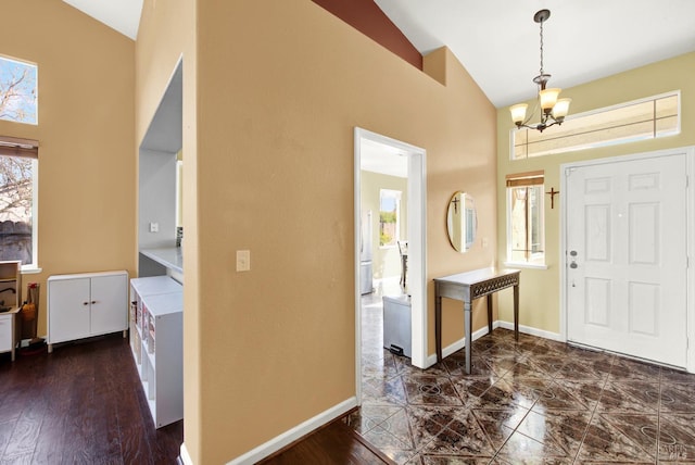 entrance foyer featuring a chandelier, baseboards, and high vaulted ceiling