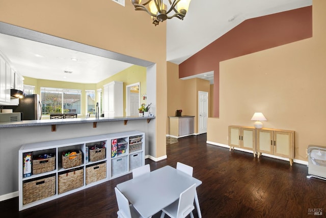 interior space featuring baseboards, vaulted ceiling, wood finished floors, and a chandelier