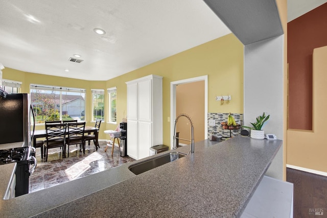 kitchen featuring recessed lighting, visible vents, a sink, gas stove, and fridge