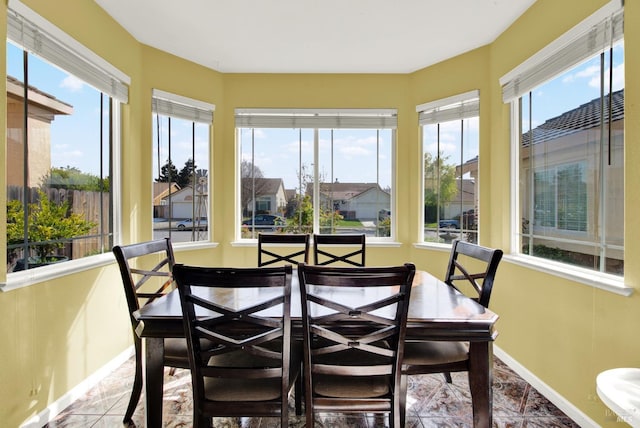 sunroom / solarium featuring baseboards and tile patterned flooring