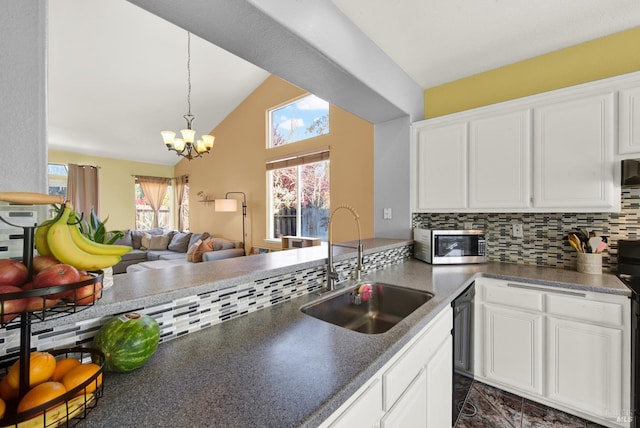kitchen with white cabinets, a sink, stainless steel microwave, a chandelier, and black dishwasher