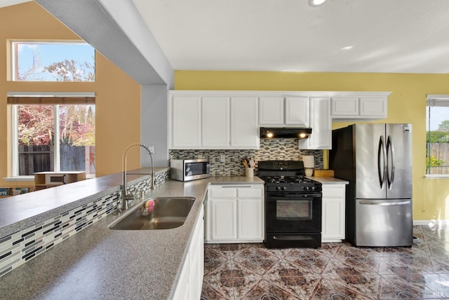 kitchen featuring a sink, decorative backsplash, stainless steel appliances, white cabinetry, and under cabinet range hood