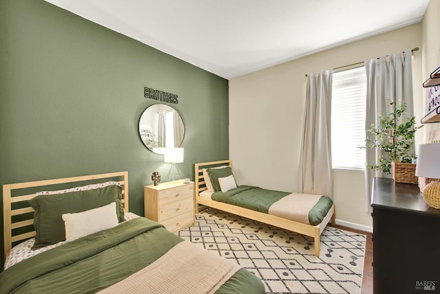bedroom featuring baseboards and wood finished floors