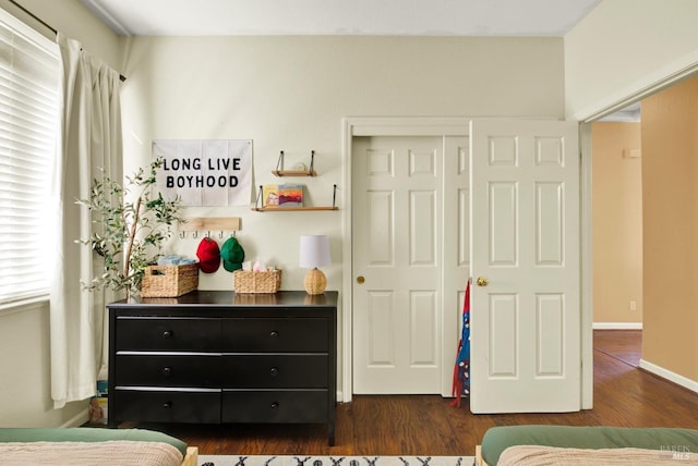 bedroom with a closet and dark wood-style flooring