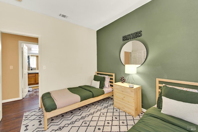 bedroom with wood finished floors, visible vents, and baseboards