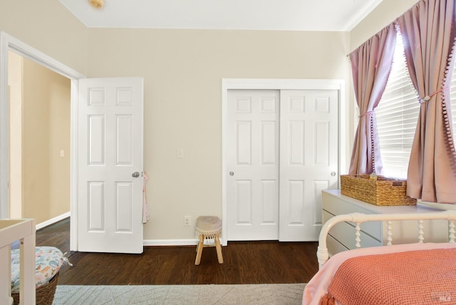 bedroom with baseboards, wood finished floors, and a closet