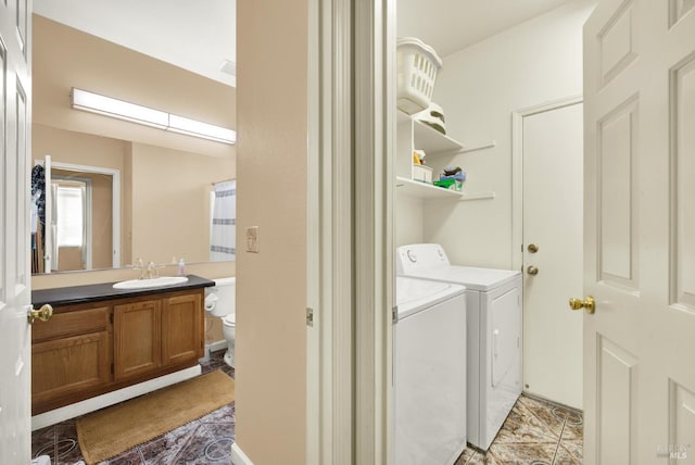 clothes washing area with washer and clothes dryer, a sink, and light tile patterned floors