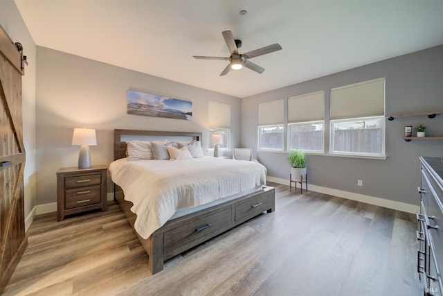 3982 Lucero St, Napa, CA 94558 - bedroom with a barn door, wood finished floors, baseboards, and a ceiling fan