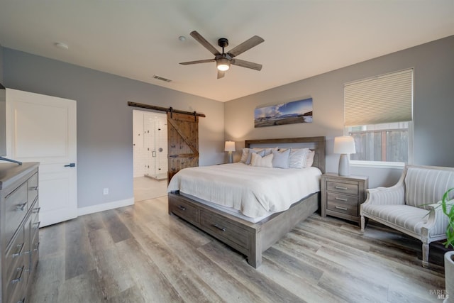 3982 Lucero St, Napa, CA 94558 - bedroom with a barn door, wood finished floors, baseboards, and a ceiling fan