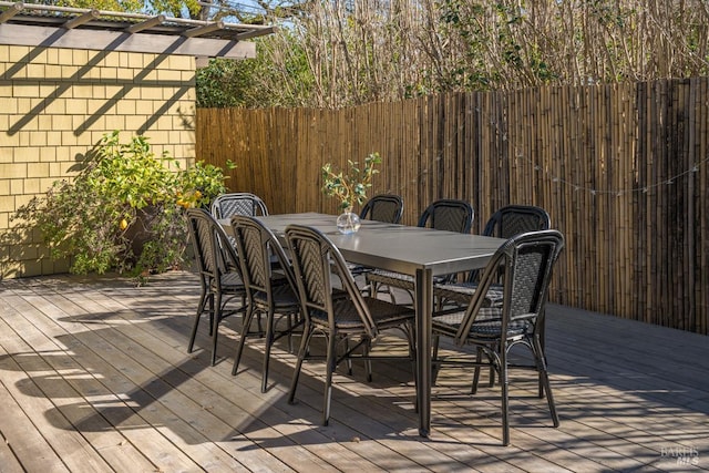 wooden terrace featuring outdoor dining space and fence