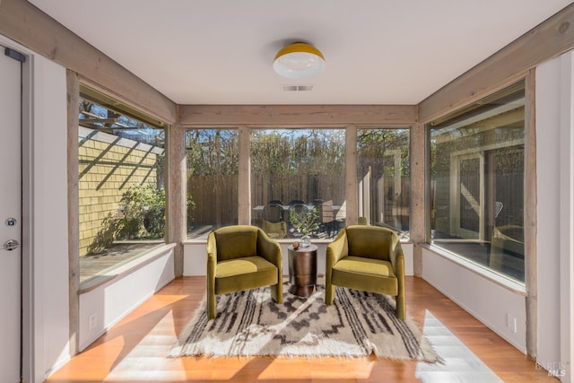 sunroom / solarium featuring wood finished floors, visible vents, and plenty of natural light