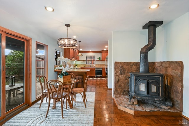 dining area with recessed lighting, a wood stove, and a chandelier