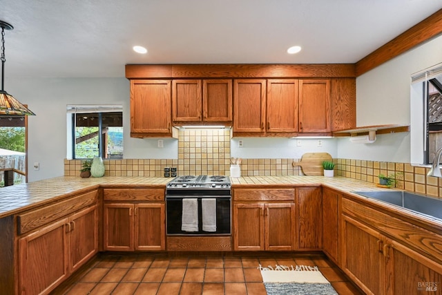 kitchen with tile counters, stainless steel electric range, and plenty of natural light