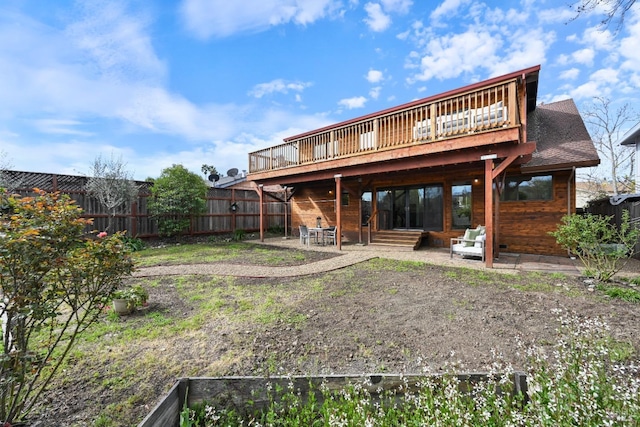 rear view of property featuring a patio, a deck, and a fenced backyard